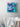 Painting of a woman diving under waves with two whales hanging on the wall above a bathtub.