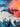 Close up of painted Dolphins jumping out of ocean waves in front of sunset sky.