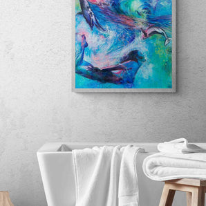 Painting of a woman diving under waves with two whales hanging on the wall above a bathtub. 