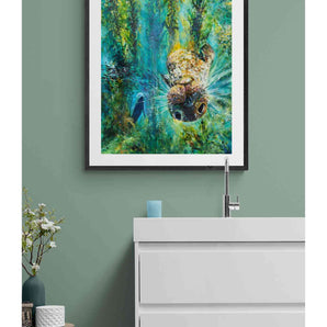 Framed painting of a seal swimming through a kelp forest. It is hanging on the wall of a bathroom. 