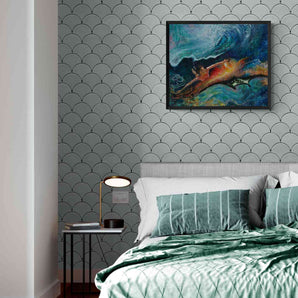 Framed painting of a woman diving under waves with a manta ray, they are floating from coral reefs into a galaxy. The painting hangs above a bed with green sheets.